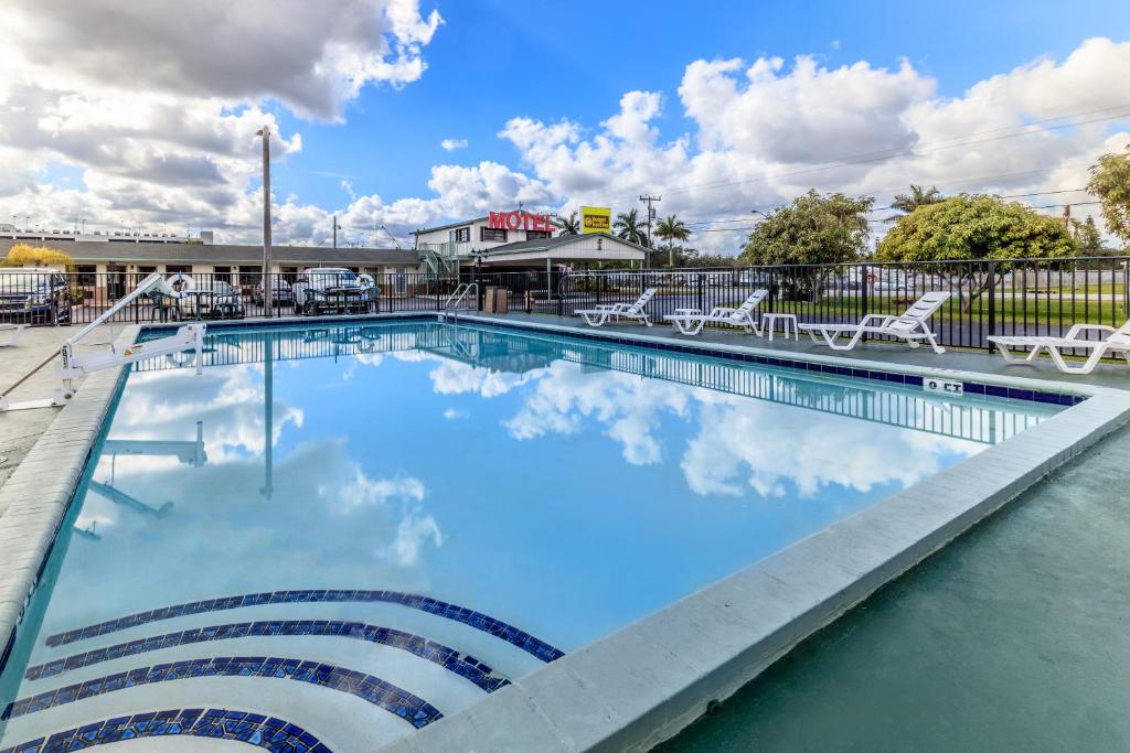 uma piscina com nuvens na água em Budget Host Inn Florida City em Florida City