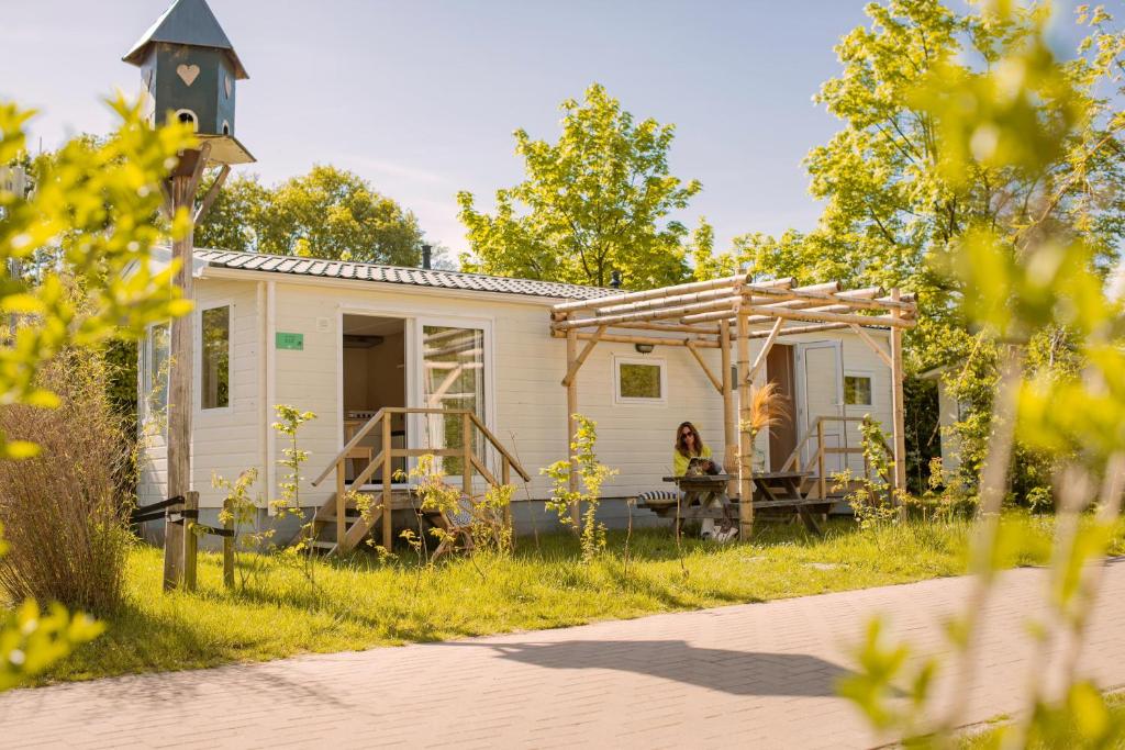 a tiny house in the middle of a field at Zomerhuisje Chalet in Voorthuizen