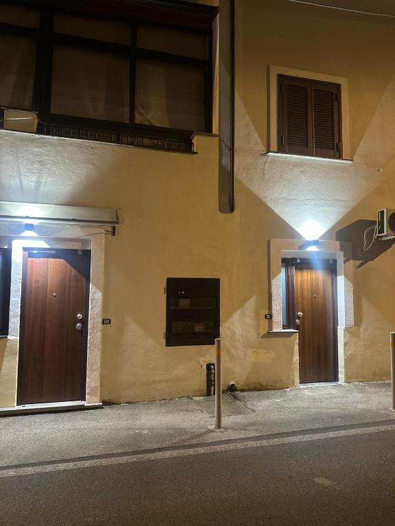 two doors on the side of a building at night at Aer in Caserta