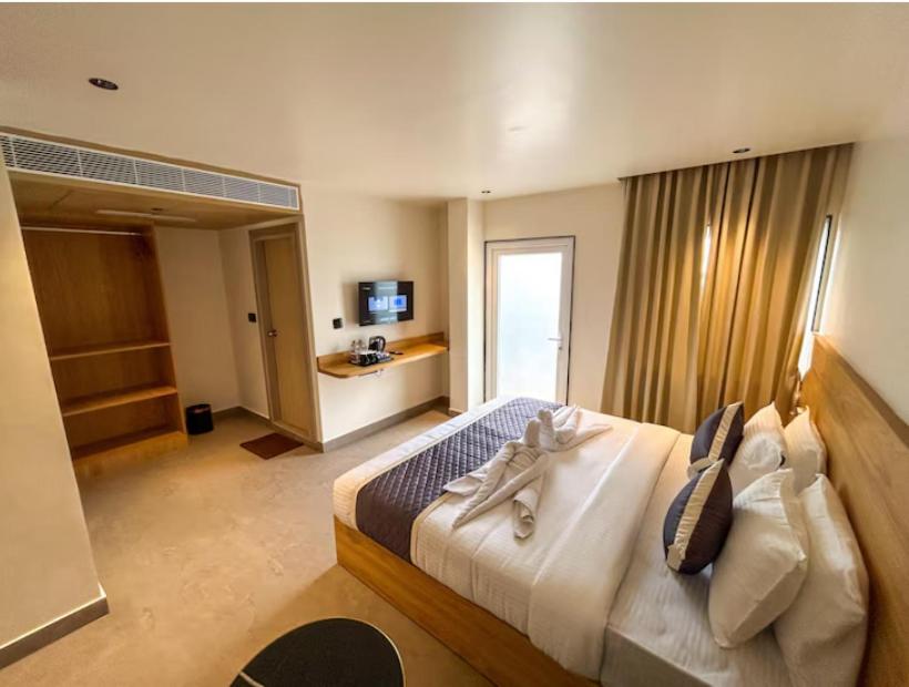 a bedroom with a large bed in a room at Hotel Orelio - Airport Hotel in Bangalore