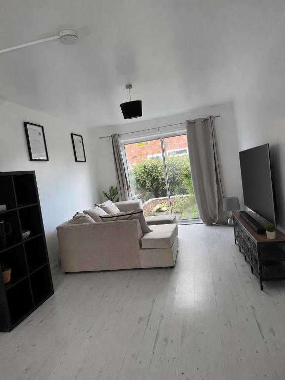 a white living room with a couch and a television at Stylish 4BR Home - Sleeps 7 - Parking & WiFi in Nottingham