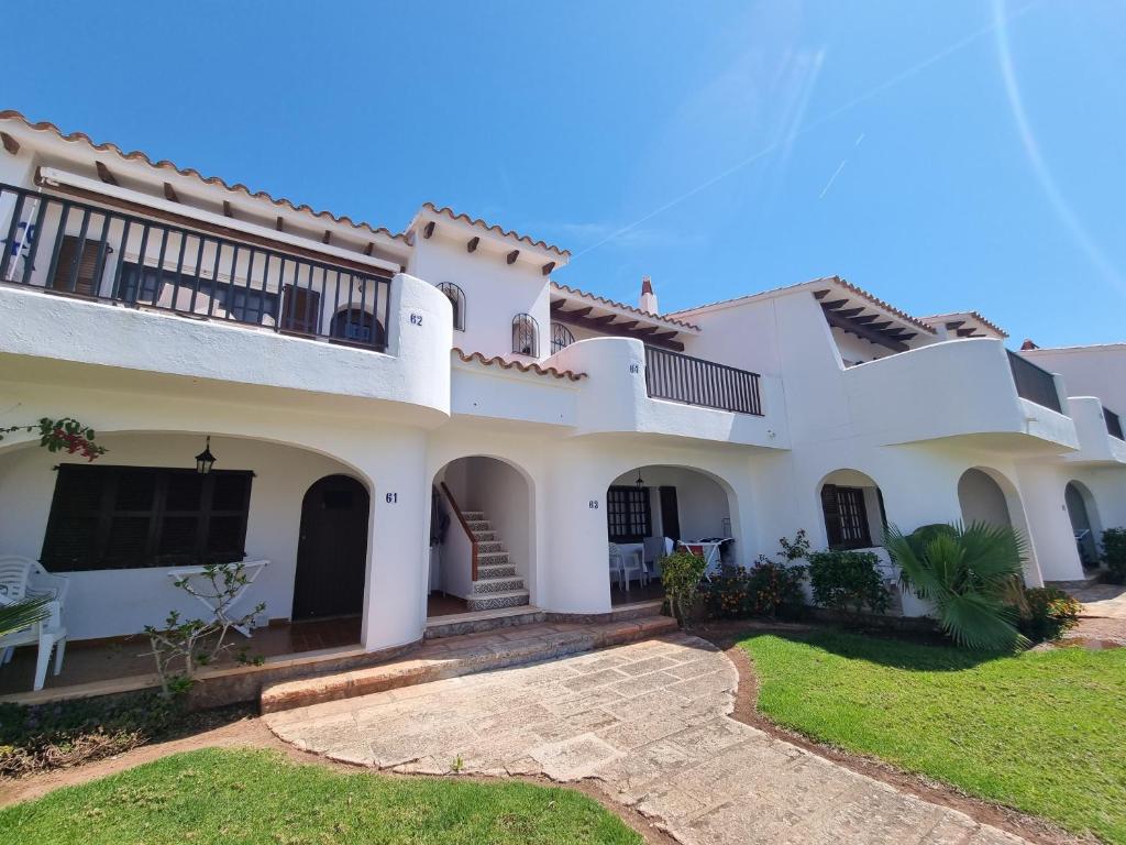 a large white house with a balcony at Posidonia -Son Bou Apartment in Son Bou