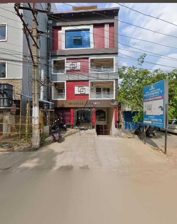 a tall building with a red and white at Srilakshmi Residency in Tirupati