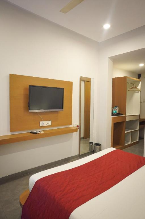 a hotel room with a bed and a flat screen tv at Hotel Paradise in Chākan