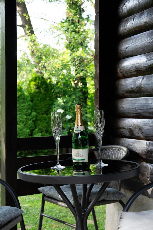 a bottle of champagne and two wine glasses on a table at Apartma Dobnik in Mozirje