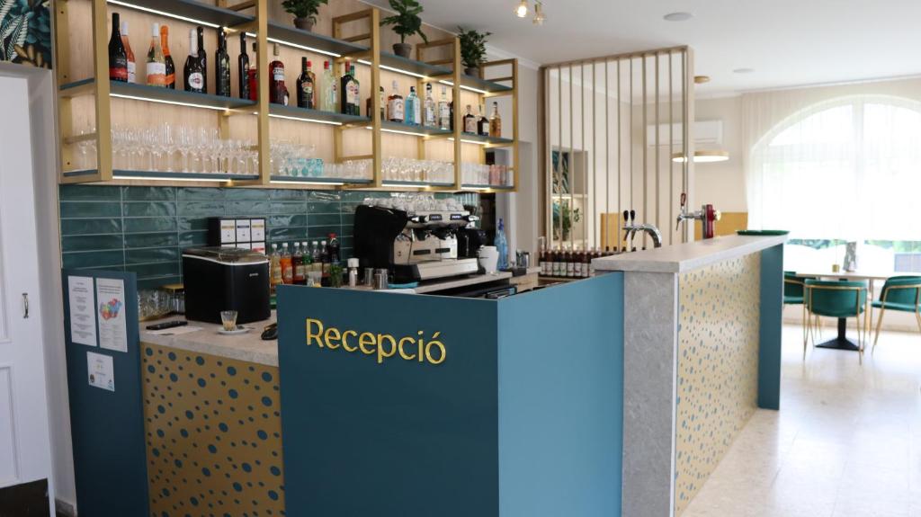 a bar in a restaurant with a counter with alcohol at Menta Rooms & Bar in Kapuvár