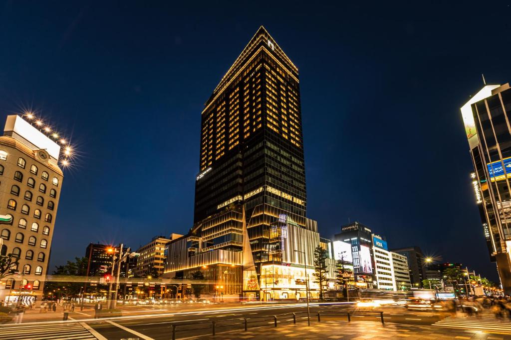 a tall skyscraper in a city at night at The Gate Hotel Osaka by Hulic in Osaka