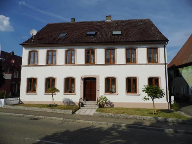 a large white house with a brown roof at Dinkelsbühl-Ferienappartement in Mönchsroth