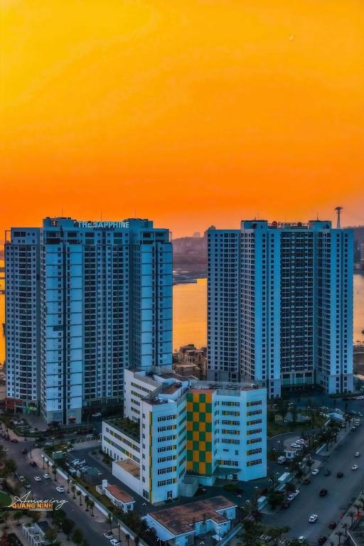 a group of tall buildings in a city at sunset at The Sapphire Hòn Gai Apartment - Trung tâm Hạ Long in Ha Long