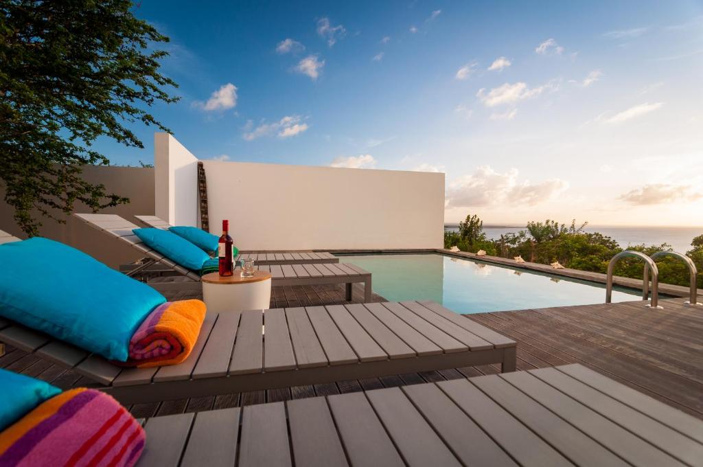 a swimming pool with a table and chairs on a patio at Bonaire Bay View Villa in Kralendijk