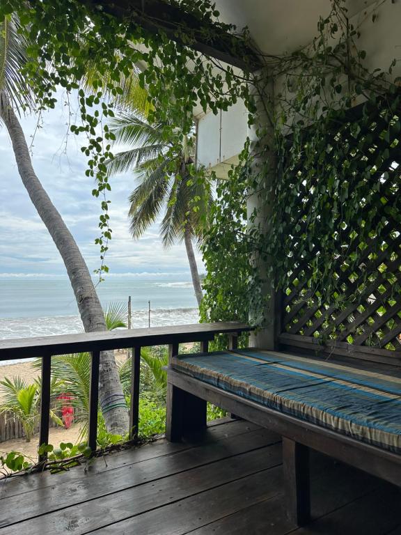 a bench on a deck with a view of the beach at Surf Resort Arugambay in Arugam Bay