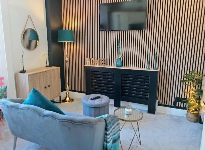 a living room with a blue couch and a tv at Cosy Seaside Snug in Helensburgh