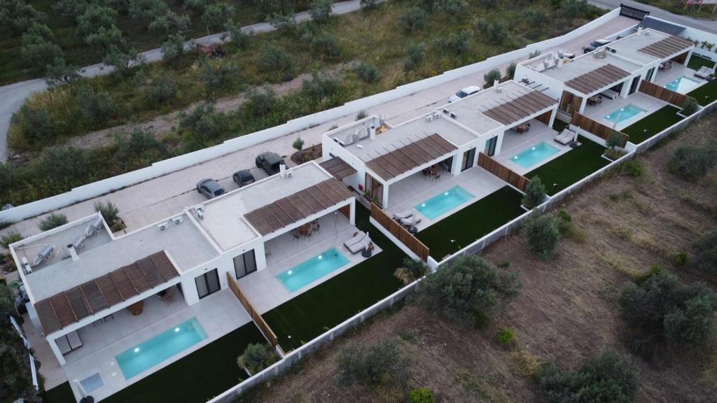 an overhead view of a large white house with swimming pools at Kudos Luxury villas in Korinthos