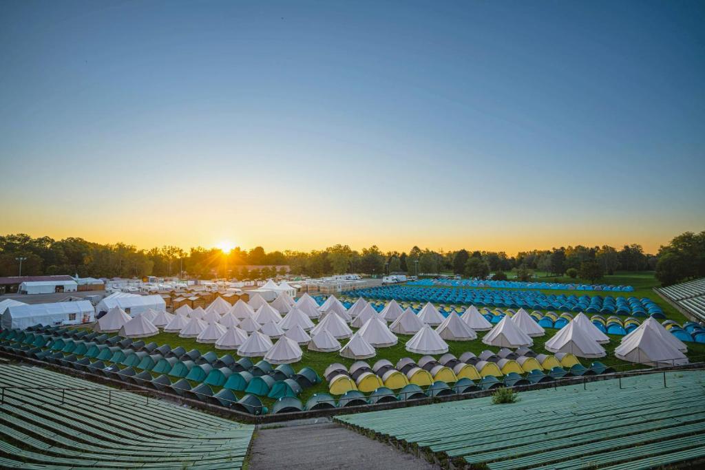 a group of white tents in a field at sunset at Wies'n Camp in Munich