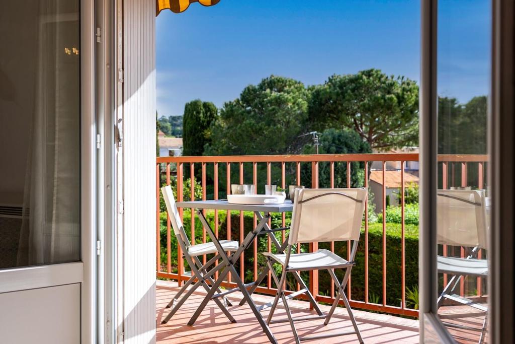 a balcony with a table and two chairs on a porch at A deux pas de la plage de sable in Le Pradet