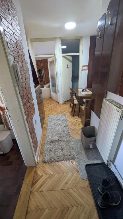 a living room with wood floors and a room with a table at apartman Stojković - Banja Ždrelo na 10 min in Petrovac na Mlavi