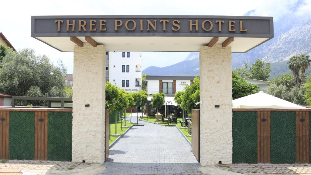 Ein dreizackiges Hotelschild über einem Tor in der Unterkunft Three Points Hotel in Beldibi