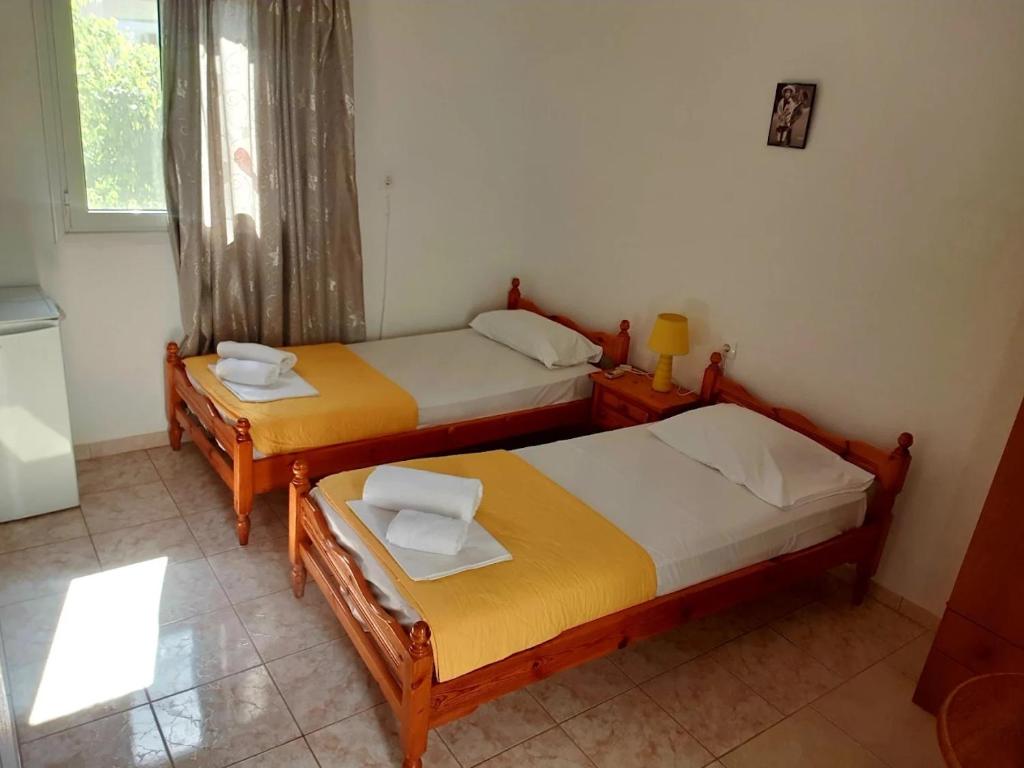 two twin beds in a room with a window at Studio Maria Lenta in Lentas