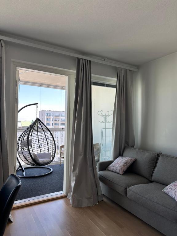 a living room with a couch and a large window at Onnellinen Koti in Vaasa