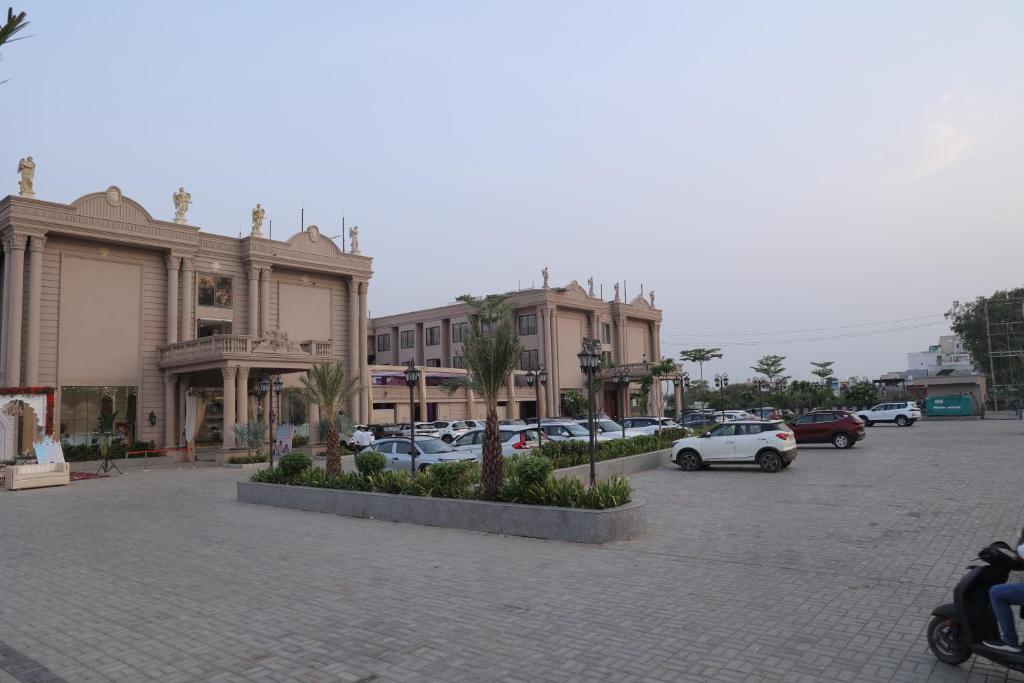a parking lot with cars parked in front of buildings at Sai Krishna Hill View Resort in Pawārkhera