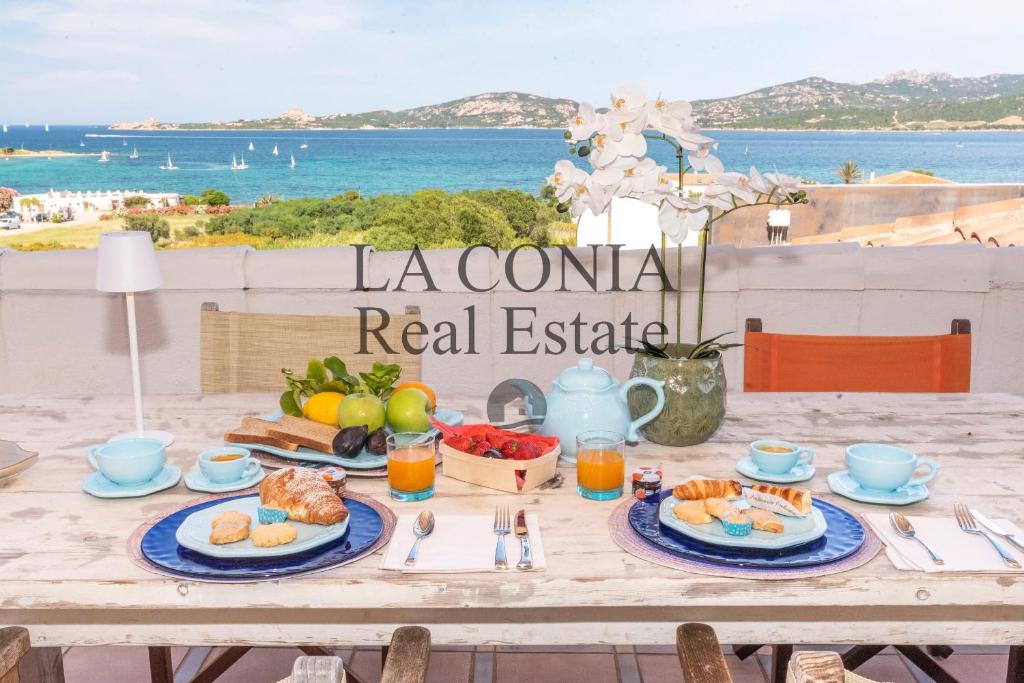 a table with food and a view of the ocean at Case Vacanze La Conia in Cannigione