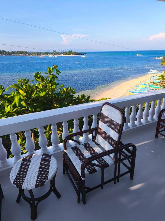 a balcony with two chairs and a view of the beach at The Clifftop Home Deluxe in Esperanza