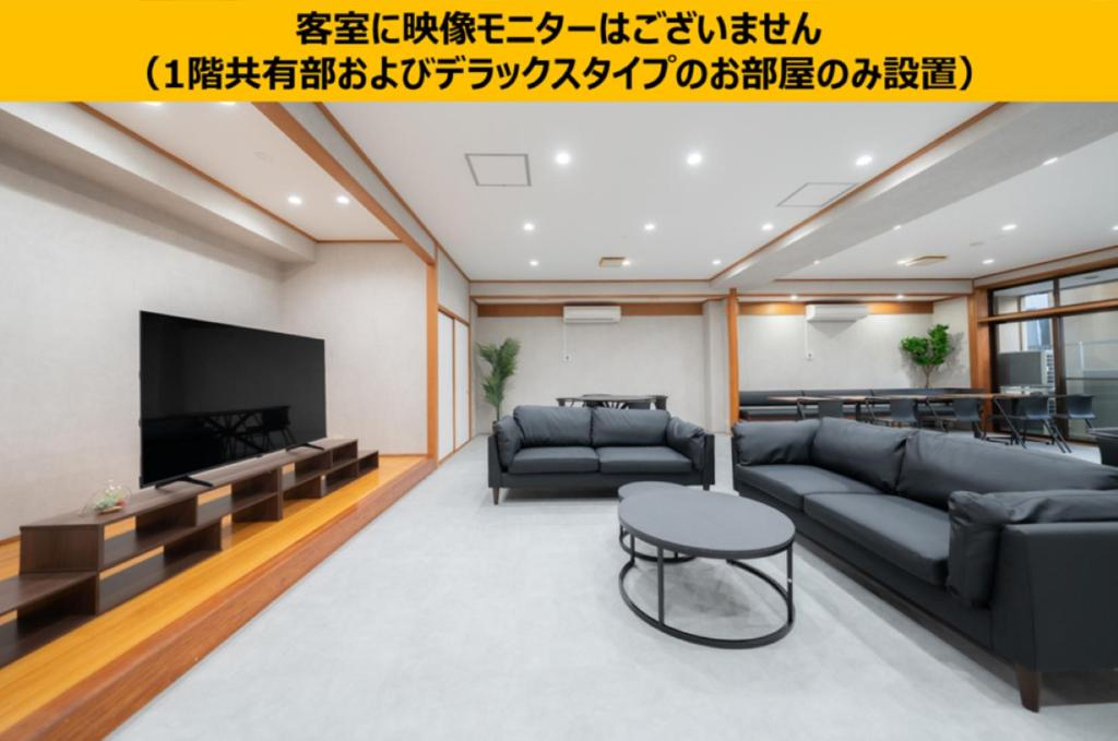 a living room with a couch and a tv at Casa GS Osaka Port in Osaka