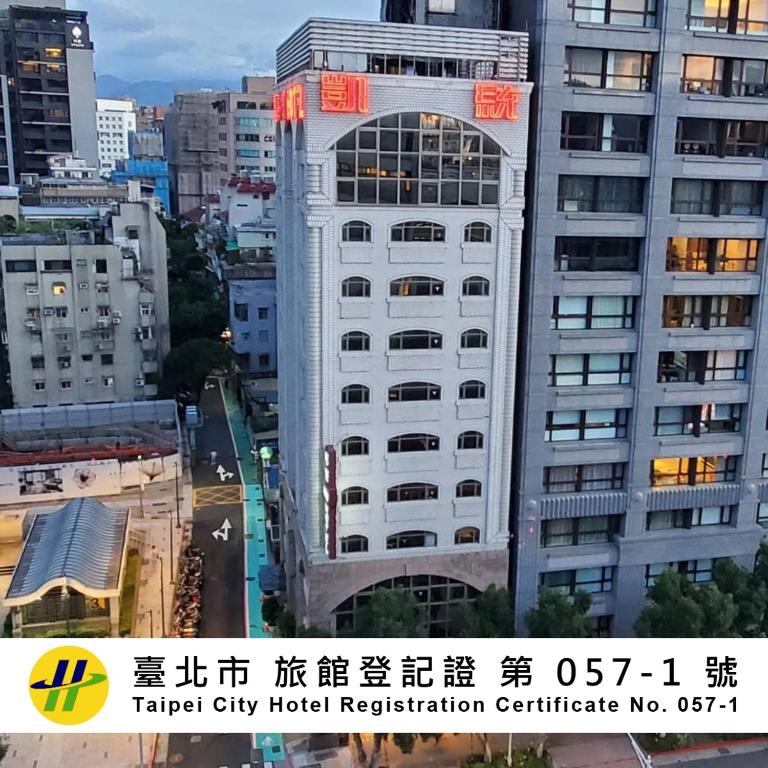 a tall white building with a red sign on it at KDM Hotel in Taipei
