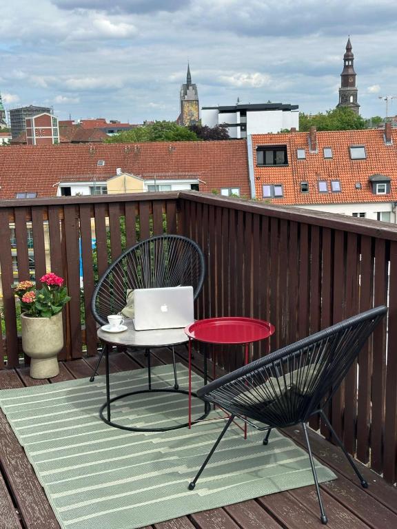 a chair and a table with a laptop on a balcony at Aparthotel Lenau in Hannover