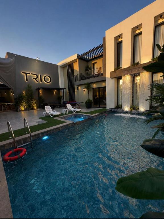 a swimming pool in front of a building at TRIO Chalet 2 in Sowayma