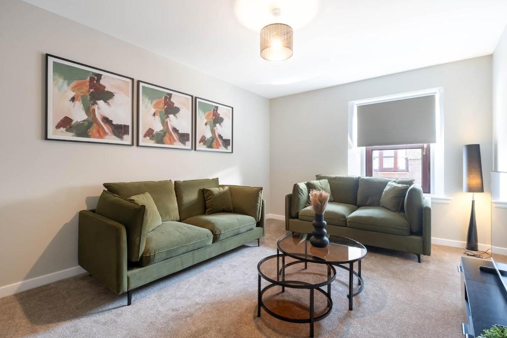 a living room with two couches and a table at Almanythie Snug, Peterhead in Peterhead