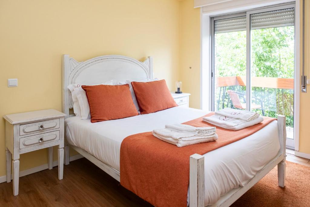 a bedroom with a bed with orange pillows and a window at RH Charming Apartment Liberdade I in Braga