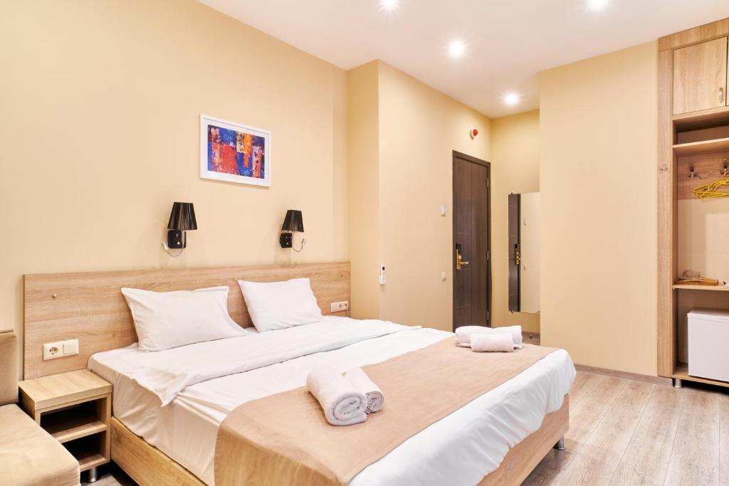 a bedroom with a large bed with towels on it at Hotel Date in Tbilisi City