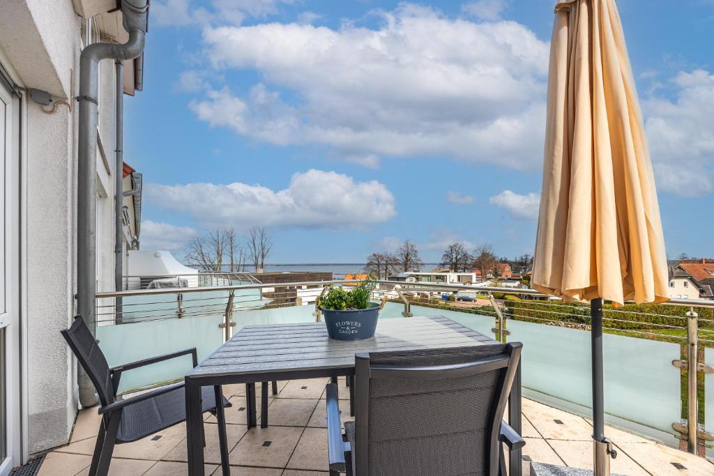 a table and chairs on a balcony with an umbrella at Studio in Steinhude