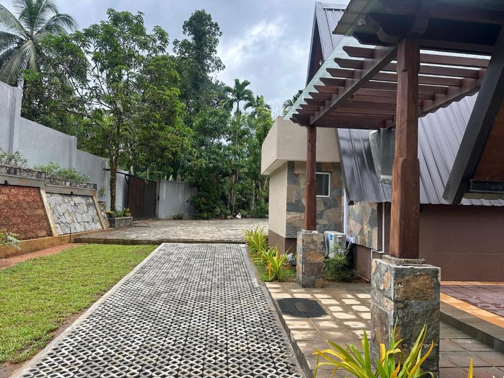a house with a stone walkway next to a building at Kithulgala Cabana Resort in Kitulgala