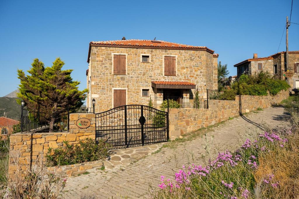 a stone building with a gate in front of it at Salkım Otel Gökçeada in Gokceada Town