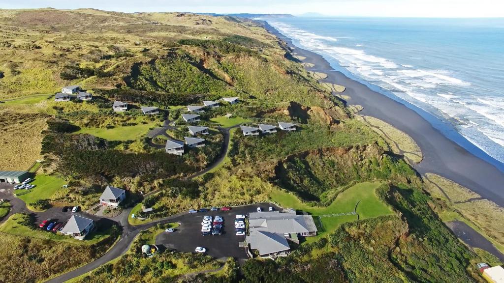 an aerial view of a house on a hill next to the ocean at Castaways Resort in Waiuku