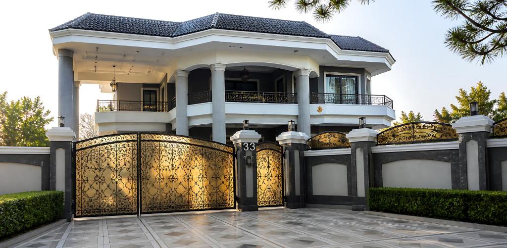 a white house with a gate and a fence at Hillside Residence E-7 by Paramount Hospitality in Islamabad