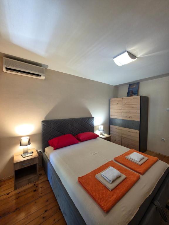 a bedroom with a large bed with two towels on it at Apartmani Dado in Sutomore