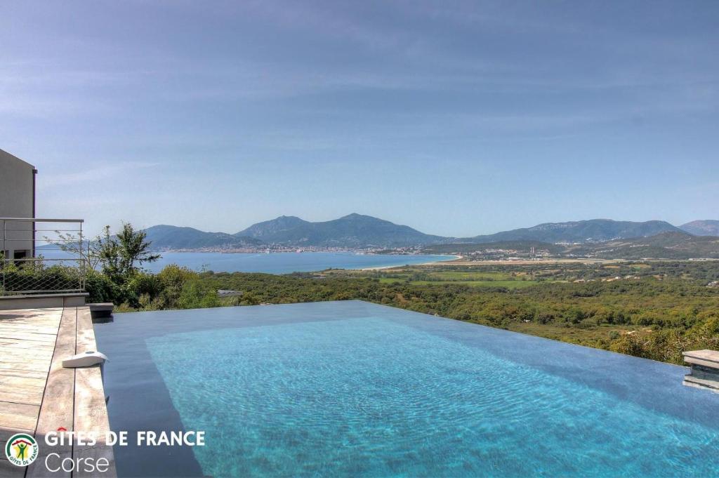 a villa with a swimming pool and a view of the water at La lunera in Porticcio