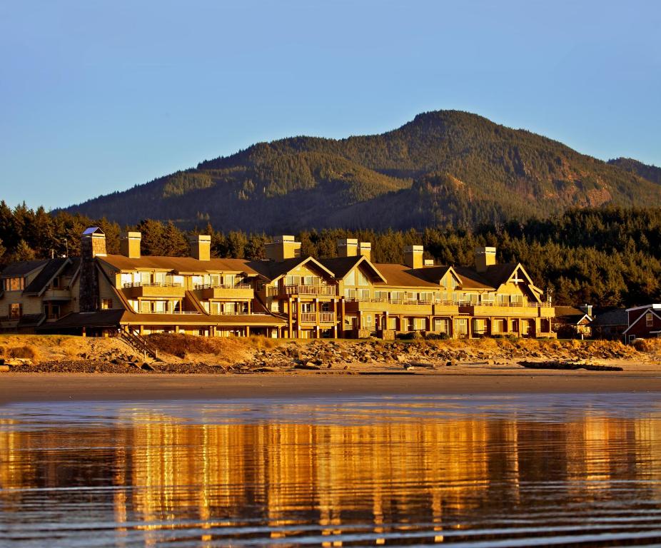 a hotel on the shore of a lake with a mountain at The Ocean Lodge in Cannon Beach