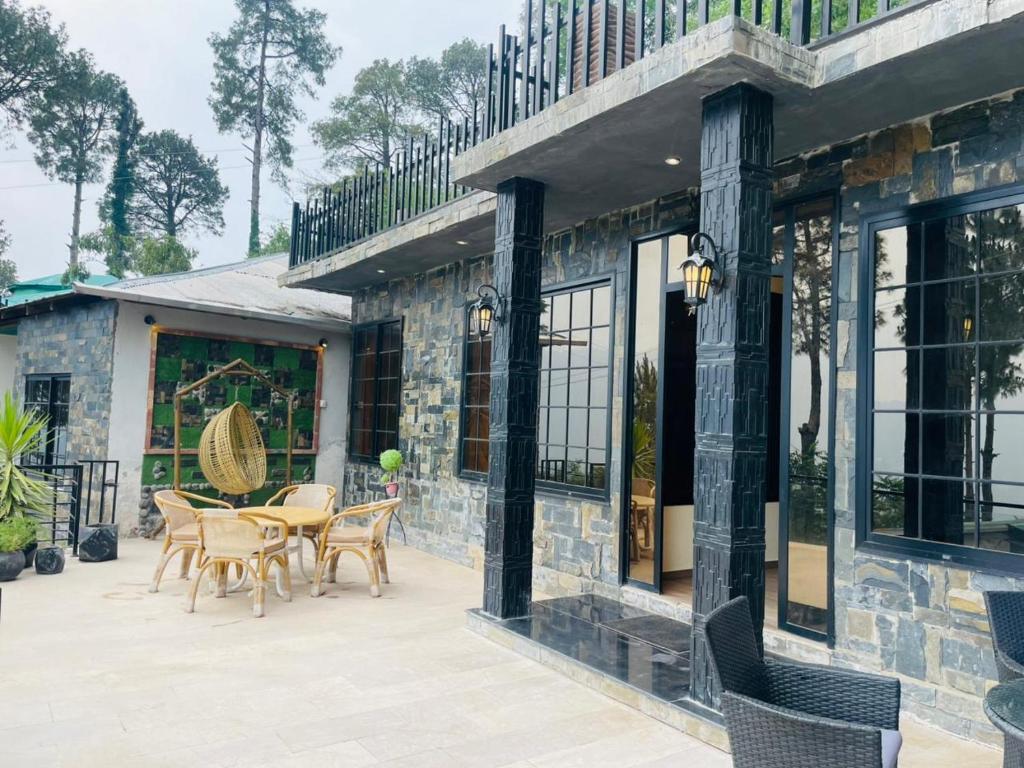 a patio with a table and chairs and a building at Hestia by Gunner Lodges in Patriata