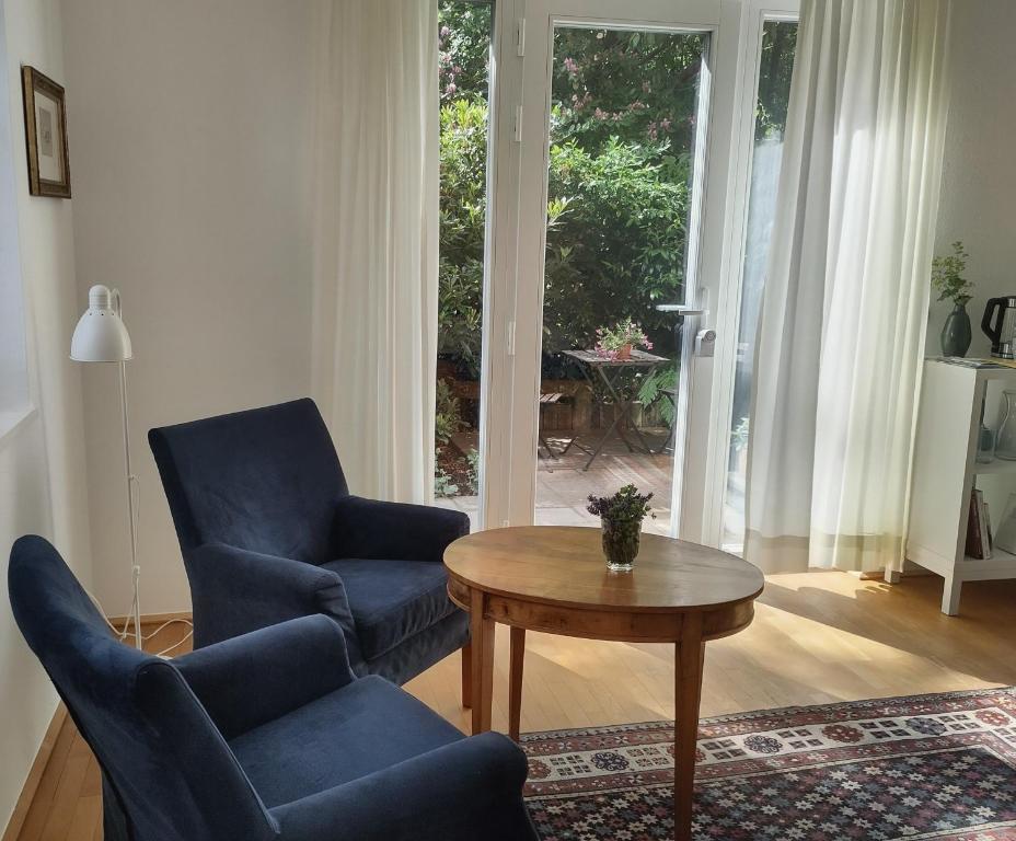 a living room with a blue chair and a table at Zimmer am Ring - ruhiges Zimmer im Grünen, Frühstück auf eigener Terrasse mit Morgensonne und fußläufig zum Badeplatz Schwarzindien am Mondsee in Sankt Lorenz