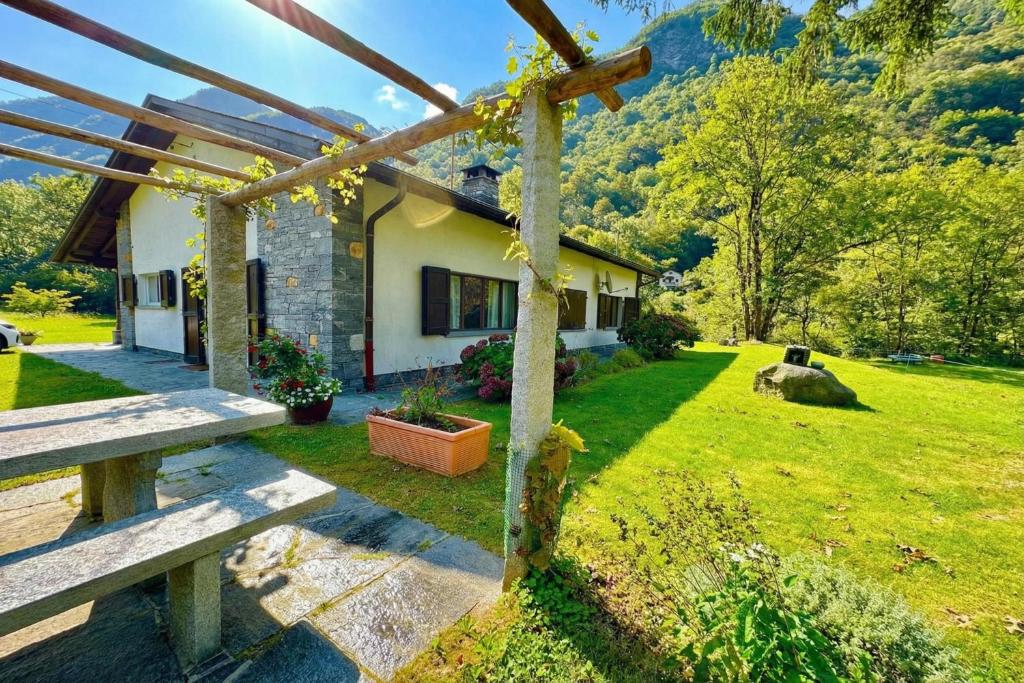 a house with a yard with a bench in front of it at Casa Mima Chalets in Gerra Verzasca