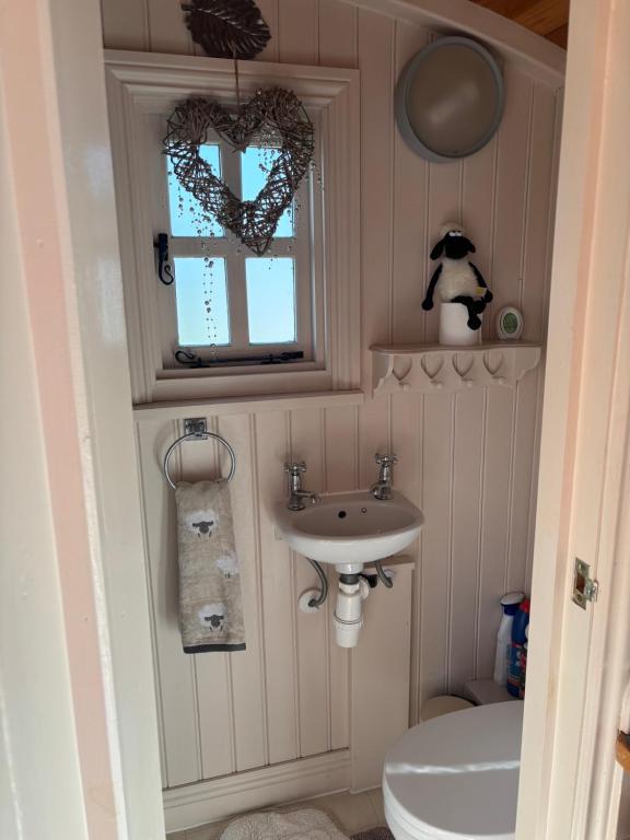a bathroom with a sink and a toilet and a window at Shepherds Rest in Peak Forest