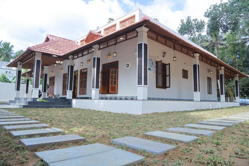 a house with a pathway in front of it at NilaTheeram in Trivandrum