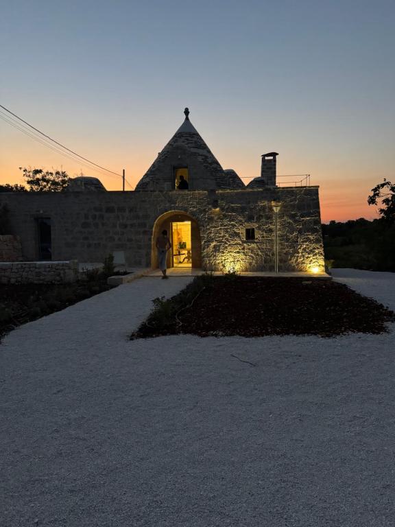 Eine Person, die im Eingang eines Steingebäudes steht in der Unterkunft Trullo Cervillo in Cisternino