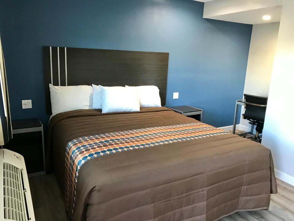 una camera da letto con un grande letto con pareti blu di Empire Inn a Los Angeles
