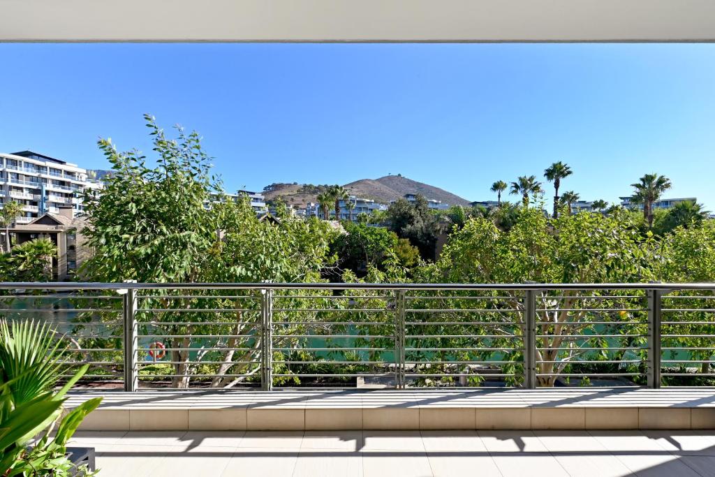 a balcony with a fence and trees at Marina 107 in Cape Town