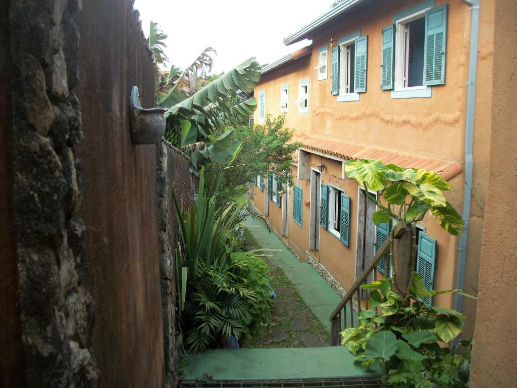 Une allée avec des plantes et un bâtiment dans l'établissement Pousada Beija-Flor, à Lavras Novas